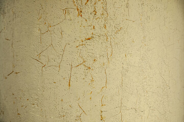 劣化したクリーム色の塗装が割れて錆が滲んでいる