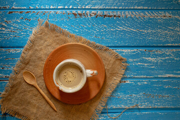 Cup of hot coffee in the morning on a blue rural wooden table