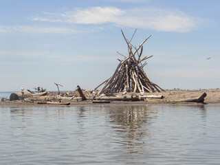 Wooden teepee along the lake