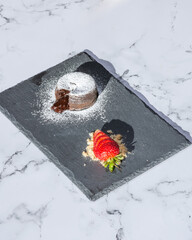 Chocolate Lava Cake Served With Strawberries On A Marble Countertop