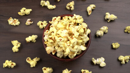 Heap of delicious popcorn. Scattered popcorn texture background. Selective focus. Salt popcorn on the wooden table.