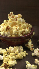 Heap of delicious popcorn. Scattered popcorn texture background. Selective focus. Salt popcorn on the wooden table.