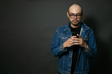 Hombre calvo guapo con camisa negra y chamarra de mezclilla