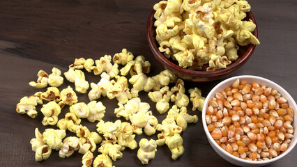 Heap of delicious popcorn. Scattered popcorn texture background. Selective focus. Salt popcorn on the wooden table.