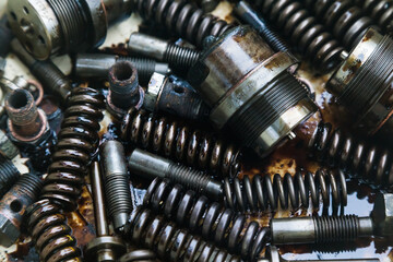 Steel mechanical parts smeared with machine oil, close-up. Steel nozzles, springs, studs, couplings...