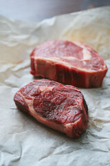 Raw steak on the table
Cooking. Raw piece of steak on the table with piece of rosemary
