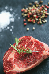 Raw steak on the table
Cooking. Raw piece of steak on the table with piece of rosemary
