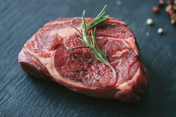 Raw steak on the table
Cooking. Raw piece of steak on the table with piece of rosemary
