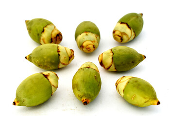 Artistic composition using green betel nut on a white background.