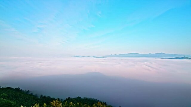 Time-lapse, sea of clouds on top of mountains and flowing clouds in the sky