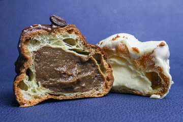 Vanilla and coffee choux pastry cake with white chocolate top on blue background.