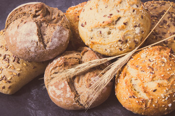 Vintage photo, Wholegrain crunchy rolls for breakfast with seeds and ears of rye or wheat grain