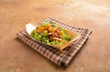 asian hakka traditional cuisine snack menu stir fried abacus ball with minced meat and mushroom in small paper bowl on wood table (suan pan zi)