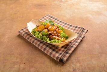 asian hakka traditional cuisine snack menu stir fried abacus ball with minced meat and mushroom in small paper bowl on wood table (suan pan zi)