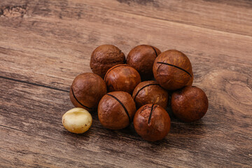 Brown macadamia nut heap over background