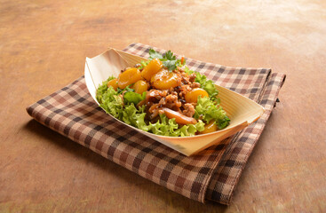 asian hakka traditional cuisine snack menu stir fried abacus ball with minced meat and mushroom in small paper bowl on wood table (suan pan zi)