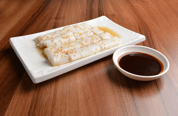 asian breakfast Chee cheong fan rice noodle with sweet sauce and sesame seed on white plate wood table chinese halal dim sum menu