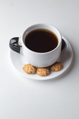 Taza de café con galletas y granos en fondo blanco