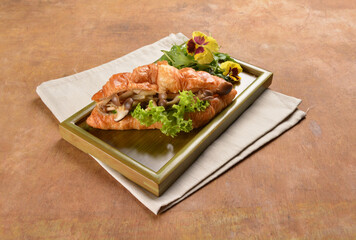 asian stir fried assorted mushroom and vegetables in freshly baked croissant on bamboo plate and flower wood table fusion halal vegetarian vegan menu