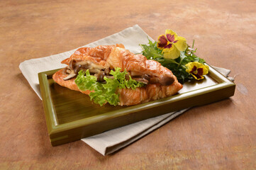 asian stir fried assorted mushroom and vegetables in freshly baked croissant on bamboo plate and...