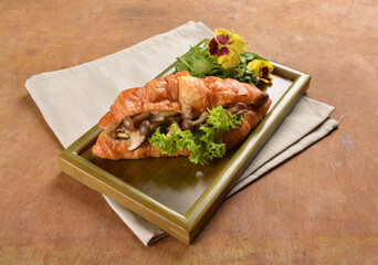 asian stir fried assorted mushroom and vegetables in freshly baked croissant on bamboo plate and...