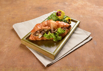 asian stir fried assorted mushroom and vegetables in freshly baked croissant on bamboo plate and...