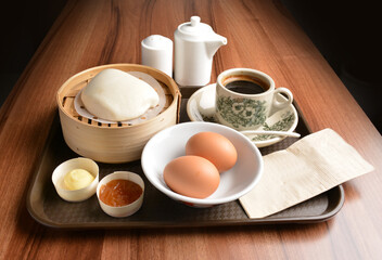 asian local traditional breakfast set halal menu with half boiled egg, baked roti mantou bun with butter and kaya jam and hot kopi coffee drink cuisine