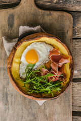Dutch baby pancake with egg, greens  in a cast-iron pan, top view, sunlight, healthy breakfast idea