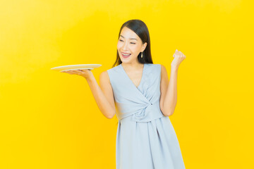 Portrait beautiful young asian woman smile with empty plate dish