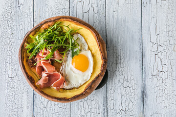 Dutch baby pancake with egg, greens  in a cast-iron pan, top view, sunlight, healthy breakfast idea