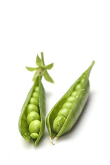 Pods of green peas with leaves isolated on white background