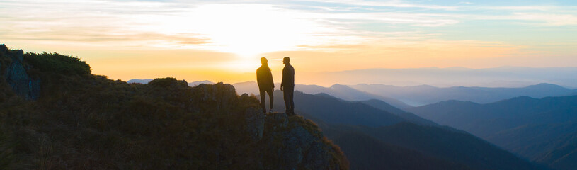 The couple standing on the mountain on the sunrise background - Powered by Adobe