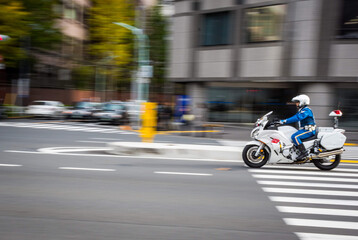 Unidentified Japanese traffic police is riding the motorcycle on the road. The picture is panning...