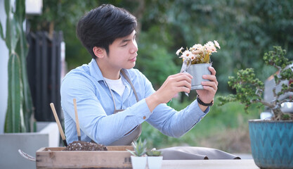 Cropped shot of man trimming florist ties a rope to arrange modern bouquet