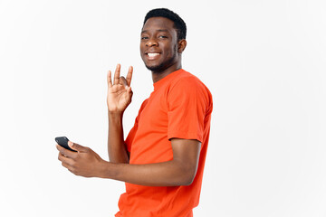  man african mobile phone gesturing with his hands and orange t-shirt light background