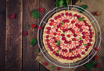 Tart with strawberries, raspberries and whipped cream decorated with mint leaves. Top view, overhead