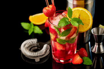 Strawberry mojito with lemon and mint isolated on black background with reflection