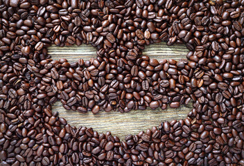 Obraz premium Funny face made from coffee beans. Creative vision of the coffee theme. The pleasure of coffee.