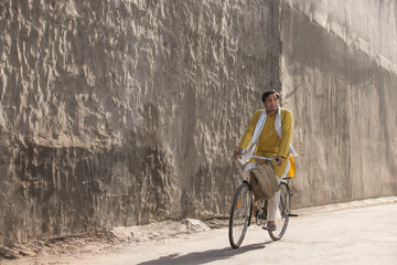A VILLAGER RIDING BICYCLE AND LOOKING AWAY