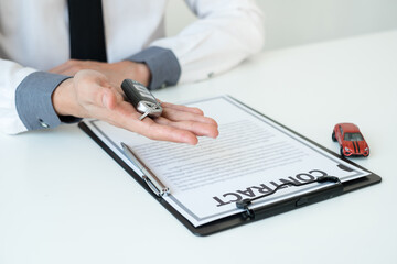 Car dealer businessman holding a car key. Car loan and insurance concept