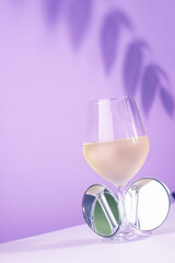 glass of white wine and on lights purple background