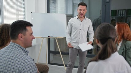 business training, young male speaker gathers hands of working team in circle raise and lower then clap each other during psychological session