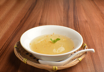 chilled sweet lemongrass jelly pudding with gui hua flower dessert in bowl on wood table asian dessert halal menu