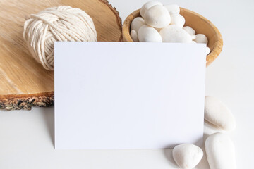Boho horizontal postcard mockup with white yarn on a white table background. Rustic bohemian image. Space for text. Good for macrame and handicrafts banners and advertisement. Copyspace mock up