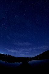 starry night sky before sunrise at lake