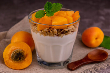 A glass of apricot yogurt with granola.
Close-up.