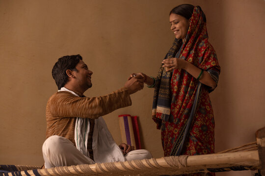 A RURAL WIFE GIVING A GLASS OF TEA TO HUSBAND - Powered by Adobe