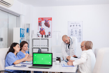 Hospital teamwork medical discovery vaccine against virus disease in conference meeting room. Mock up green screen chroma key laptop computer with isolated display standing on desk analyzing diagnosis