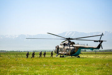 Military helicopter with soldiers. Armed conflict between Israel and Palestine, military action. A soldier in camouflage clothing goes to a military helicopter. Air armament, parachutist. © Vera