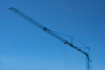 the lattice jib of a blue construction crane